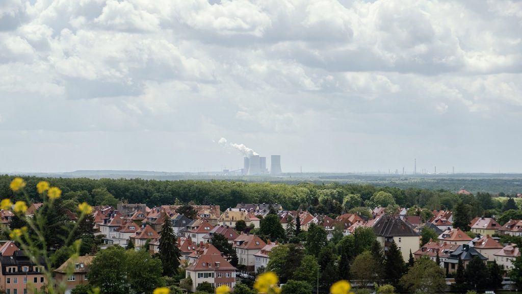 Residential houses in the foreground, with a large power station on the horizon