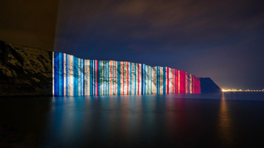 Warming Stripes projected onto the White Cliffs of Dover at night.