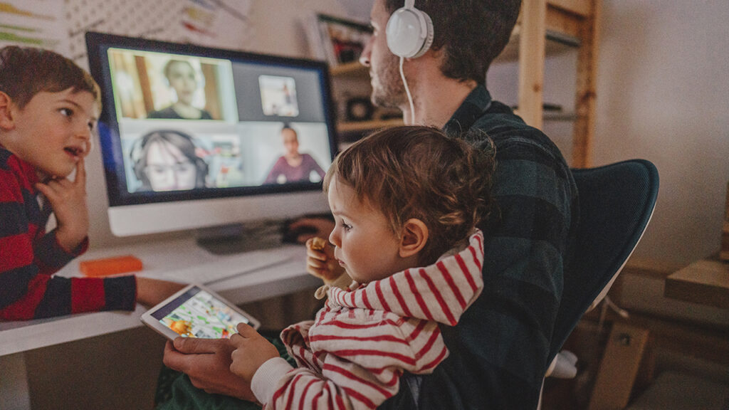 A man is working from home with his two sons as a company, having a video conference call